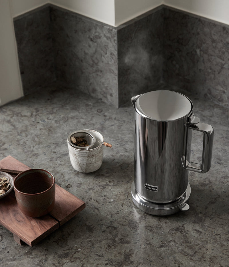 Aarke | Stainless Steel Kettle on a counter next to a cup, showcasing its modern design and durable construction, ideal for sustainable water heating.