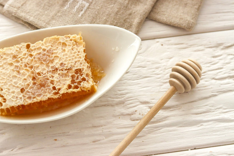 Beechwood Bavarian Honey Dripper displayed with honeycomb in a bowl, highlighting its handcrafted design for effortless and controlled honey drizzling.
