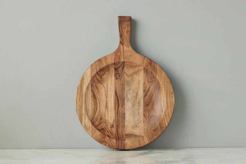 Large etúHOME Italian Cutting Board Bowl displayed on a countertop, showcasing its smooth, round wood surface and short handle, ideal for kitchen use.