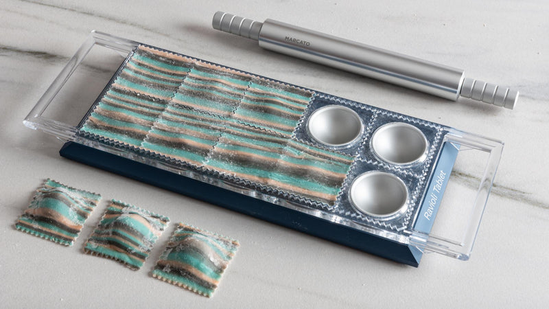 Marcato Ravioli Tablet Pasta Maker with non-skid base, shown forming and sealing ravioli, ideal for crafting homemade pasta effortlessly.