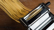 Marcato | Atlas 150 Pasta Maker with spaghetti, showcasing its ability to roll and cut fresh pasta dough for traditional homemade Italian dishes.