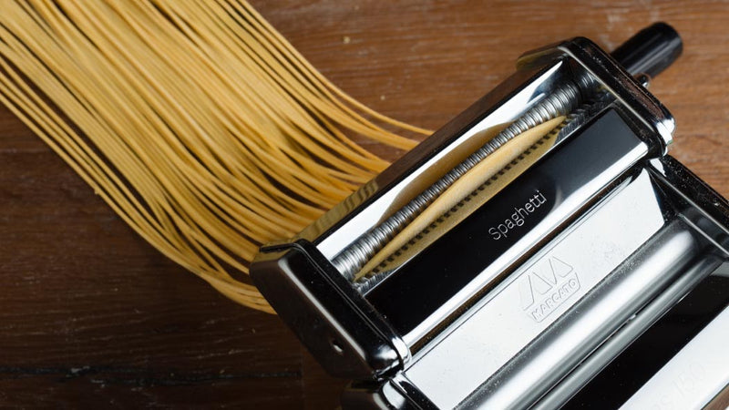 Marcato | Atlas 150 Pasta Maker with spaghetti, showcasing its ability to roll and cut fresh pasta dough for traditional homemade Italian dishes.