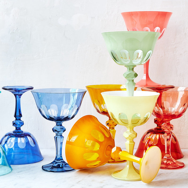 Sir/Madam Rialto glassware styled on a table in mixed colors including Honeydew green, with tumblers and coupes