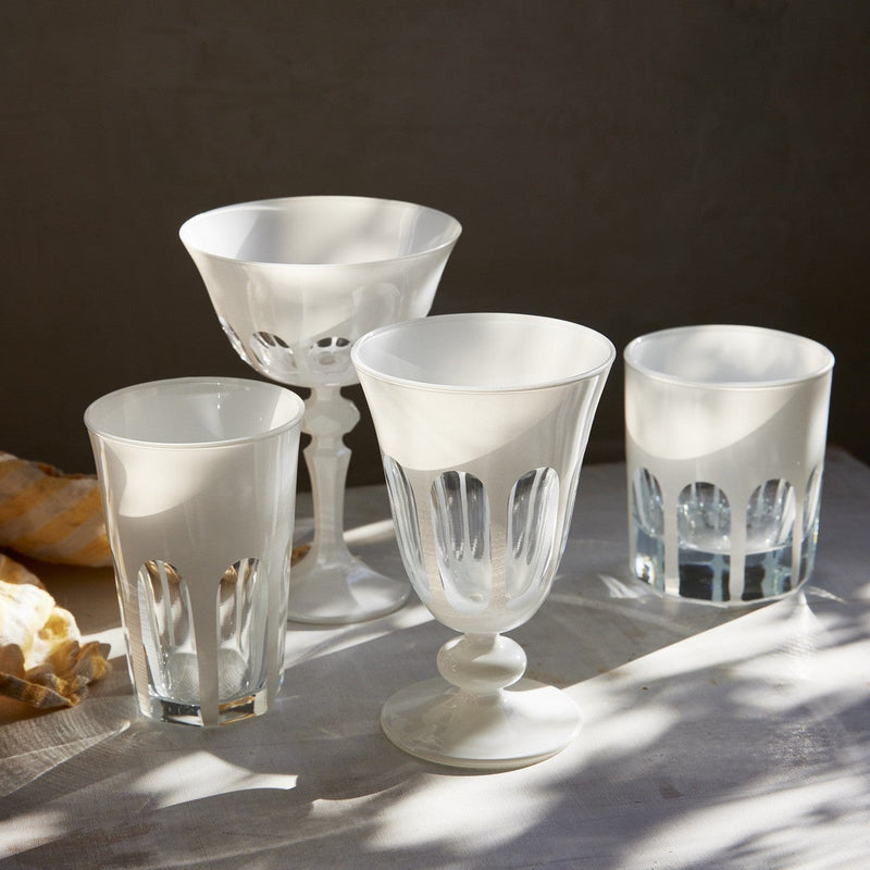 Sir|Madam Rialto Chalk glassware on a sunlit table — Coupe, Tulip, Tumbler, and Old Fashion in opaque cream