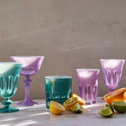 Sir|Madam Rialto Lupine coupe styled with a Menthe goblet, teal tumbler, lupine tumbler, and lupine goblet alongside fresh citrus