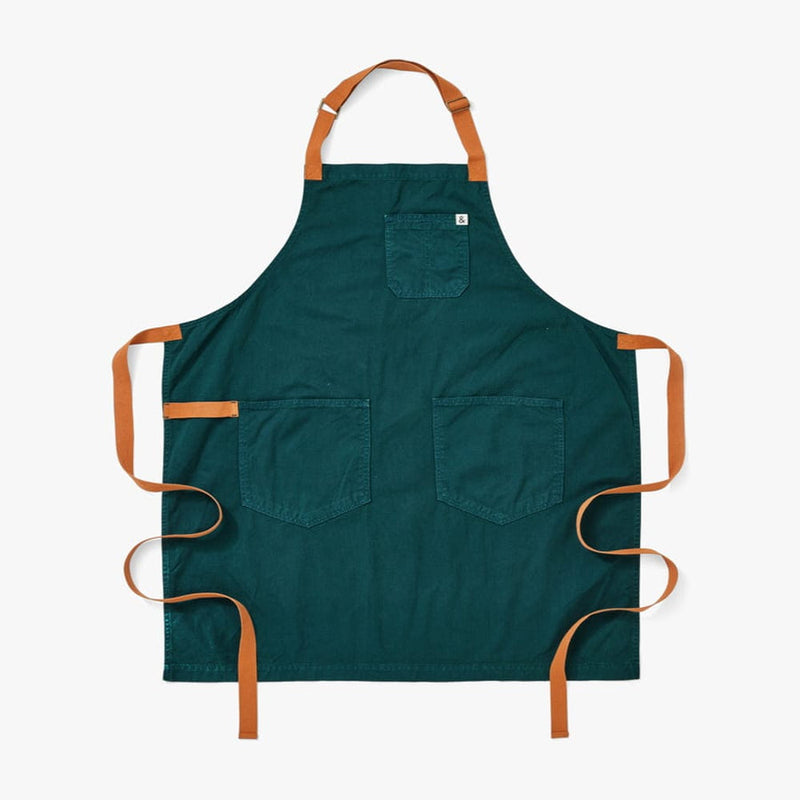 Hedley & Bennett Essential Garment Dyed - Seaweed Green apron, featuring a dark teal design with tan straps, one chest pocket, and two front pockets, ideal for kitchen use.
