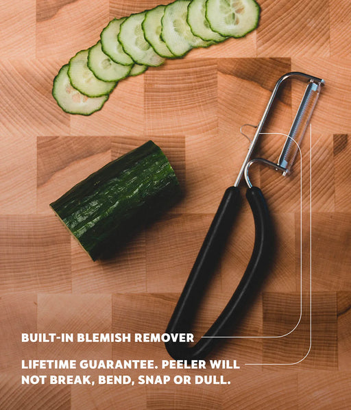 Spartan Kitchen | Spartan Peeler (Black) on a cutting board with a cucumber, showcasing its stainless steel blade and durable design, perfect for effortless peeling.