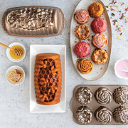 Nordic Ware | Floral Cakelet Pan with various pastries, showcasing detailed flower-shaped molds perfect for baking mini Bundt cakes.