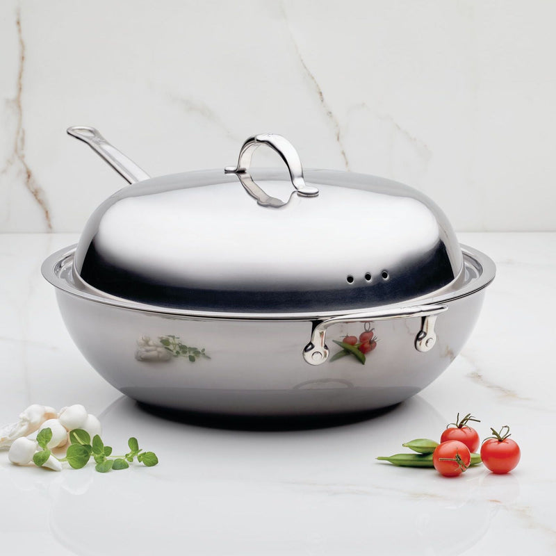 Hestan Provisions | Stainless Steel Lid Dome, 14 on a marble surface with fresh garlic, herbs, tomatoes, and pods; crafted for optimal cooking performance.