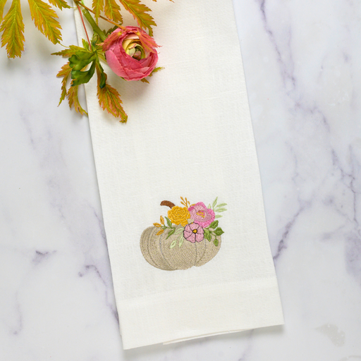 Arte Italica & Crown Linen Designs' Pumpkin Towel features a floral-embroidered pumpkin on linen, perfect for kitchen decor. Includes a hanging tab and embroidered crown detail.