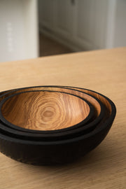 Creating Comfort Lab | Handmade Ukrainian Charred Wooden Salad Bowls, Set of 3, showcasing nested hand-carved bowls with natural wood grain interiors and charred exteriors on a light tabletop.