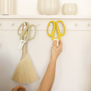 The Floral Society | Japanese Floral Clippers, Citrine, hang on a peg rail beneath a shelf with ceramic vases, highlighting their precision craftsmanship and ergonomic design.