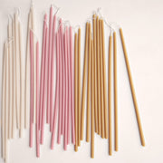 The Floral Society | Long Stem Beeswax Candles, Ochre, arranged in off-white, pale pink, and honey-yellow, showcasing their elongated, elegant form for versatile home ambiance.