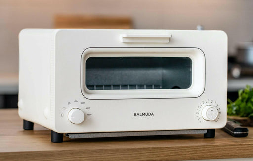 BALMUDA | The Toaster - White on a table, showcasing its sleek design and innovative steam technology for perfect toasting results. Ideal for enhancing any kitchen cooking experience.