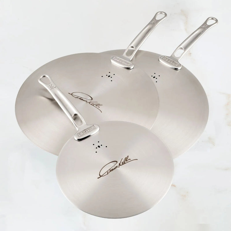 Hestan Provisions | Commercial Clad Stainless Steel Universal Lids, 8.5 Inches, showcasing three stacked lids with steam-vent holes and Thomas Keller’s signature on a countertop.