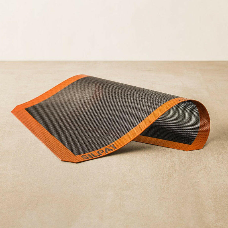 Silpat Perfect Bread - Quarter Size mat on a baking tray, ideal for baking bread and pastries; reusable, durable, and fits snugly in standard trays.