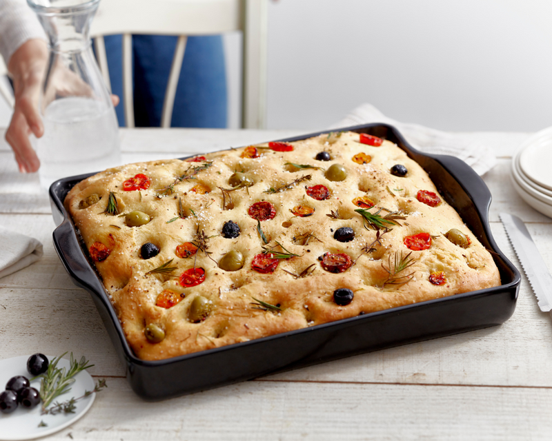 Emile Henry Modern Classics Loaf Pan, Rouge, 9 x 5 holding a freshly baked focaccia with tomatoes, olives, and herbs, showcasing its even baking and elegant presentation.