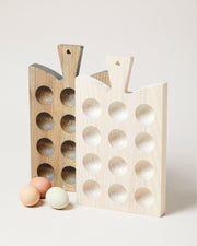 Farmhouse Pottery | Crafted Wooden Egg Boards - Cornish - White, featuring two ash wood boards with carved depressions for displaying eggs, accompanied by three pastel eggs in front.