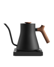 Fellow | Stagg EKG Pro Electric Kettle in matte black with walnut accents, featuring a precision pour spout, wooden handle, and variable temperature control on its power base.