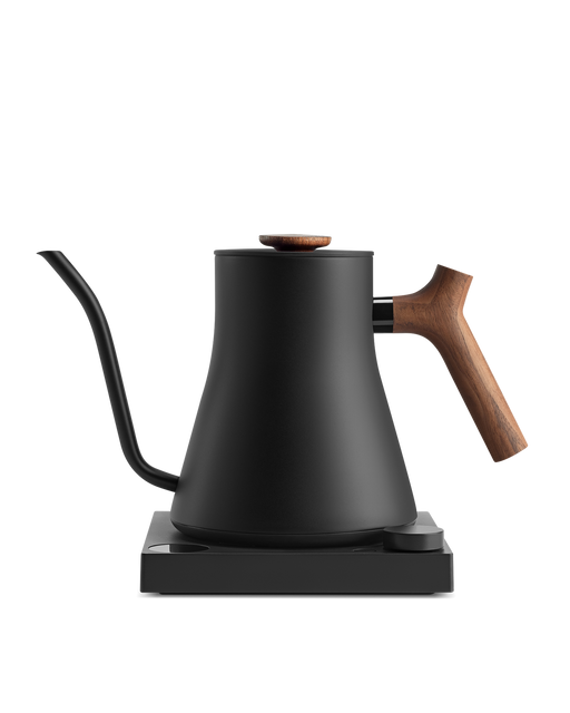 Fellow | Stagg EKG Pro Electric Kettle in matte black with walnut accents, featuring a precision pour spout, wooden handle, and variable temperature control on its power base.