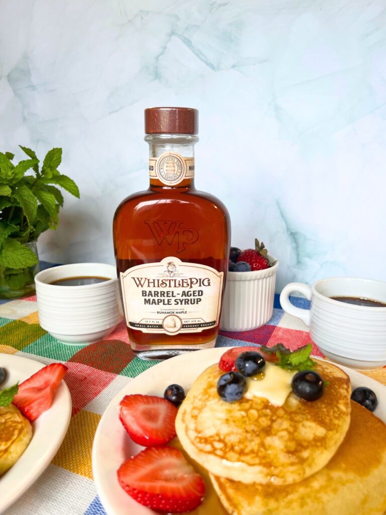 Close-up of Runamok's WhistlePig Rye Whiskey Barrel-Aged Maple Syrup bottle, highlighting its rich whiskey-infused, oak-spiced flavor, ideal for enhancing various dishes.