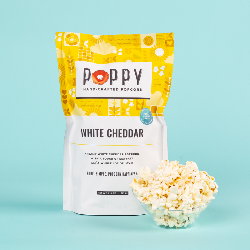 Poppy | Handcrafted Popcorns - White Cheddar alongside a bowl, highlighting its irresistible, cheesy flavor perfect for snacking during game nights or movie outings.