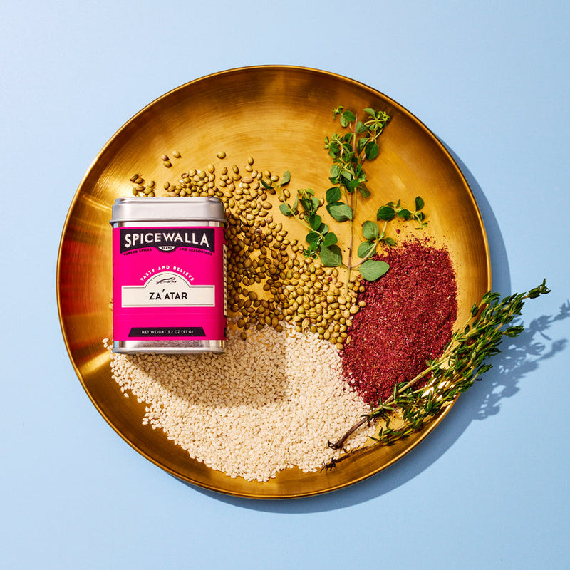 Spicewalla | Za'atar tin on brass platter with sesame seeds, coriander, sumac, and herbs, showcasing a vibrant Middle Eastern spice blend from Athens Cooks.