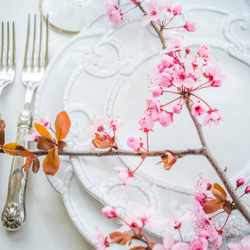 Bella Bianca Antique Lace Salad/Dessert Plate with pink flowers and silverware, crafted from Italian stoneware, showcasing a delicate, timeless design.