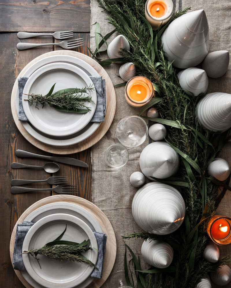 Rustic table setting featuring Farmhouse Pottery - Spruce Woodland Trees: Petite, amidst greenery and candles, on a wooden table with elegant dinnerware and linens.