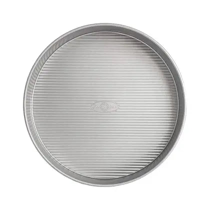 USA Pan 12 in Round Cake Pan with FDA-approved nonstick Americoat® and ridged texture for even baking, perfect for both amateur and professional bakers.