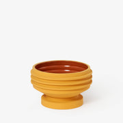 Areaware - Strata Plant Vessel: Yellow ceramic bowl with a brown center, inspired by Simone Brewster's sculptural designs, ideal for enhancing kitchen decor.