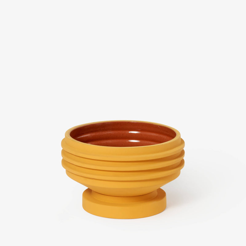 Areaware - Strata Plant Vessel: Yellow ceramic bowl with a brown center, inspired by Simone Brewster's sculptural designs, ideal for enhancing kitchen decor.
