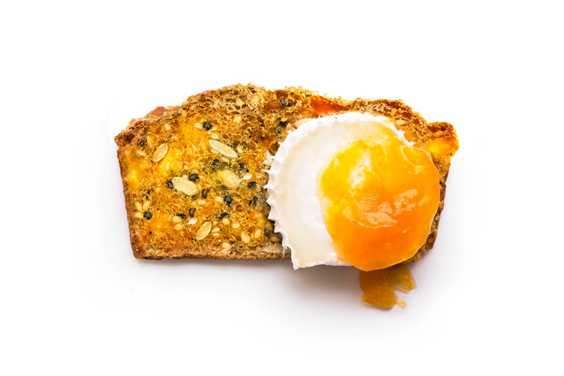 Rustic Bakery - Artisan Crisps - Citrus, Ginger & Thyme Box with seeded multigrain toast topped with a soft-poached egg, yolk oozing beautifully.