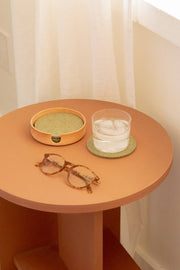 Graf Lantz - Bierfilzl Merino Wool Felt Round Coaster Solid 4 Pack: Sage on a table with a glass of water and an ashtray.