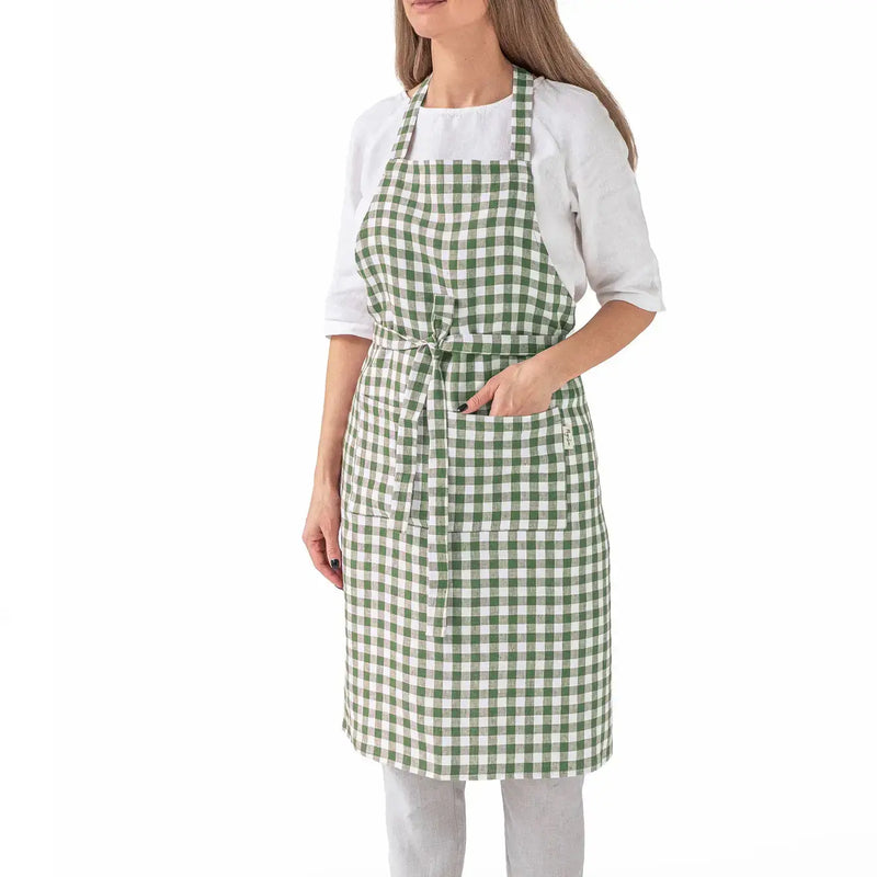 MagicLinen - Charcoal Grey Linen Bib Apron with Pockets, worn by a woman, showcasing its stylish checkered pattern and functional design. Ideal for cooking or gardening.