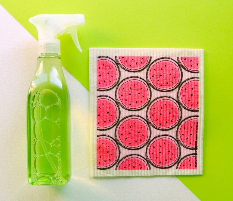 Bespoke Provisions - Watermelon Swedish Dishcloth next to a spray bottle, highlighting its eco-friendly design for cleaning various kitchen surfaces.