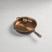 Smithey | Glass Lids: Close-up of a pan with a brass knob, showcasing premium kitchenware from Athens Cooks, a curated cookware collection.