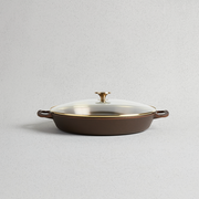 Smithey | Glass Lids: A close-up of a brown and gold pan with a glass lid, ideal for elegant serveware in your kitchen.