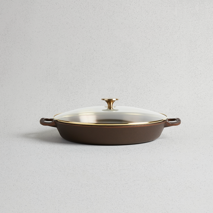 Smithey | Glass Lids: A close-up of a brown and gold pan with a glass lid, ideal for elegant serveware in your kitchen.