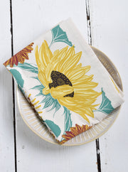 Hearth and Harrow Sunflower Tea Towel on ceramic plate; organic cotton, oversized 30x30, hand printed with sunflower design, ideal for kitchen or dining use.