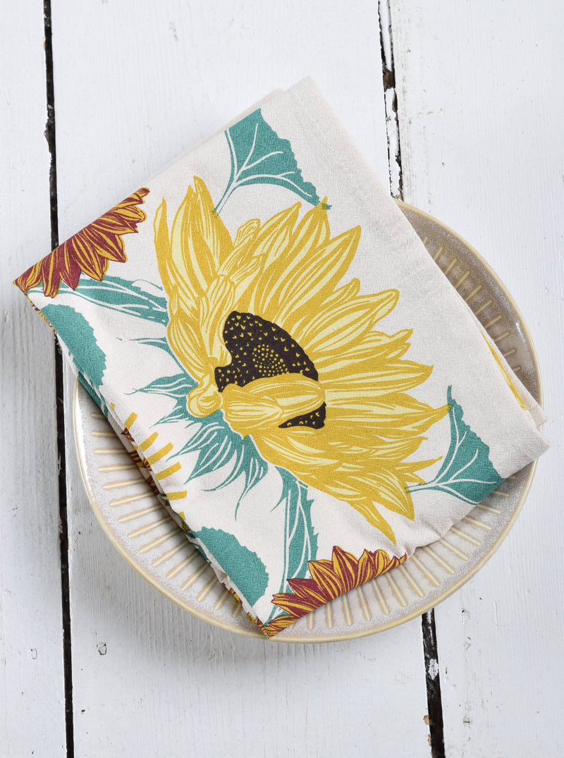 Hearth and Harrow Sunflower Tea Towel on ceramic plate; organic cotton, oversized 30x30, hand printed with sunflower design, ideal for kitchen or dining use.