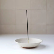 Gravesco Pottery - Incense Burner in 4 colors: A white-glazed ceramic dish holding an upright incense stick, designed to catch ash and protect surfaces.