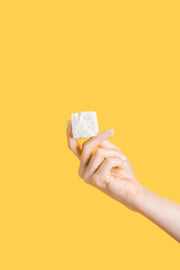 Hand holding a Honey Vanilla Mallow cube, showcasing its small size and texture. Part of Malvi Mallow - Honey Vanilla 4-Pack Marshmallows, Case of 12 Packs.