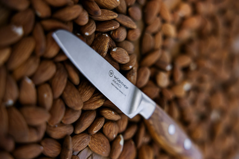 Wüsthof Amici 3 1/2 Paring Knife displayed atop a pile of nuts, highlighting its precision and craftsmanship, perfect for meticulous kitchen tasks.