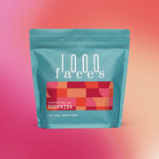 1000 Faces Coffee - Bookkisa: A blue bag with a unique design, representing a meticulously crafted coffee blend, perfect for mindful coffee enthusiasts.