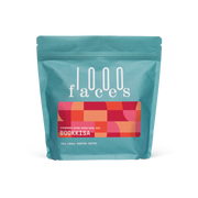 Blue bag of 1000 Faces Coffee - Bookkisa, featuring white text and red squares, highlighting exceptional blends for mindful coffee consumption.