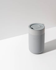 W&P - Ceramic Reusable Coffee Mug 16oz: Charcoal, featuring a grippable silicone sleeve and splash-resistant lid, ideal for eco-friendly, stylish coffee enjoyment.