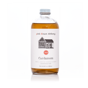 Pink House Alchemy - Cardamom Simple Syrup bottle with a white label, featuring a house image, perfect for enhancing coffee with its spicy and sweet floral notes.
