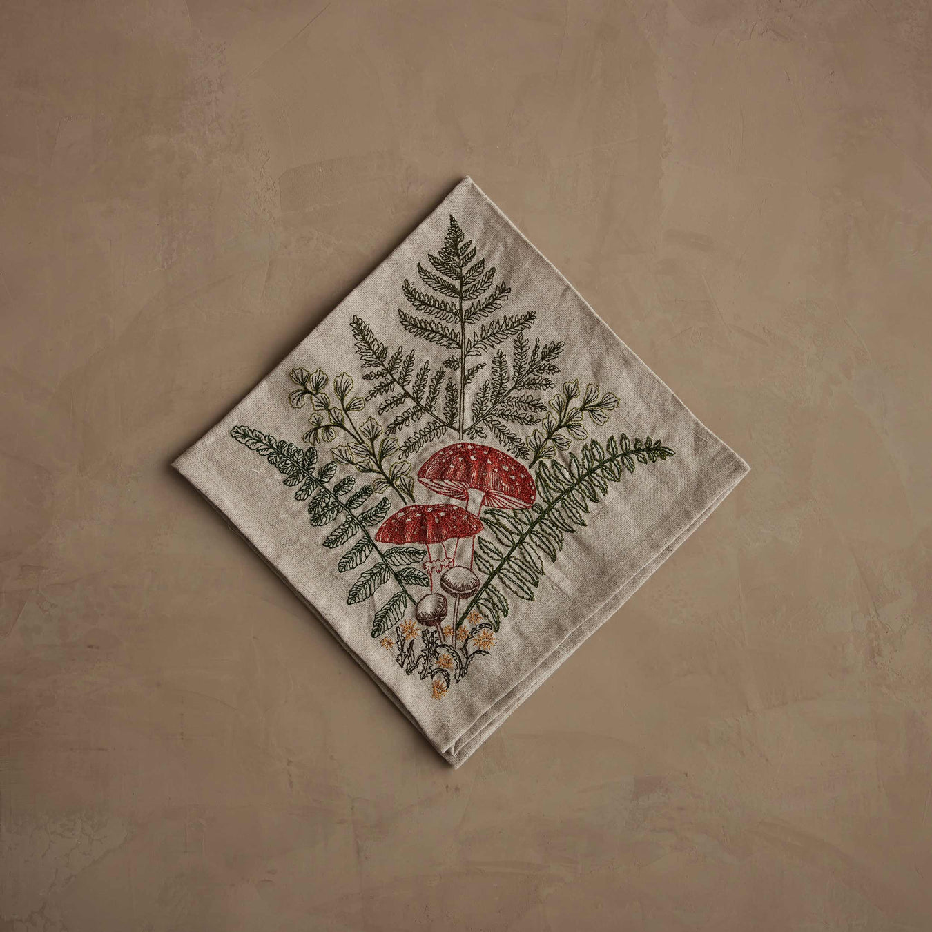 Coral & Tusk - Mushrooms and Ferns Bouquet Dinner Napkin, showcasing embroidered amanitas and ferns, perfect for enhancing a fairytale table setting with natural elegance.