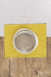 MagicLinen - Moss Yellow linen placemat set of 2 on a table, under a white speckled bowl, enhancing dining decor with natural gingham elegance.